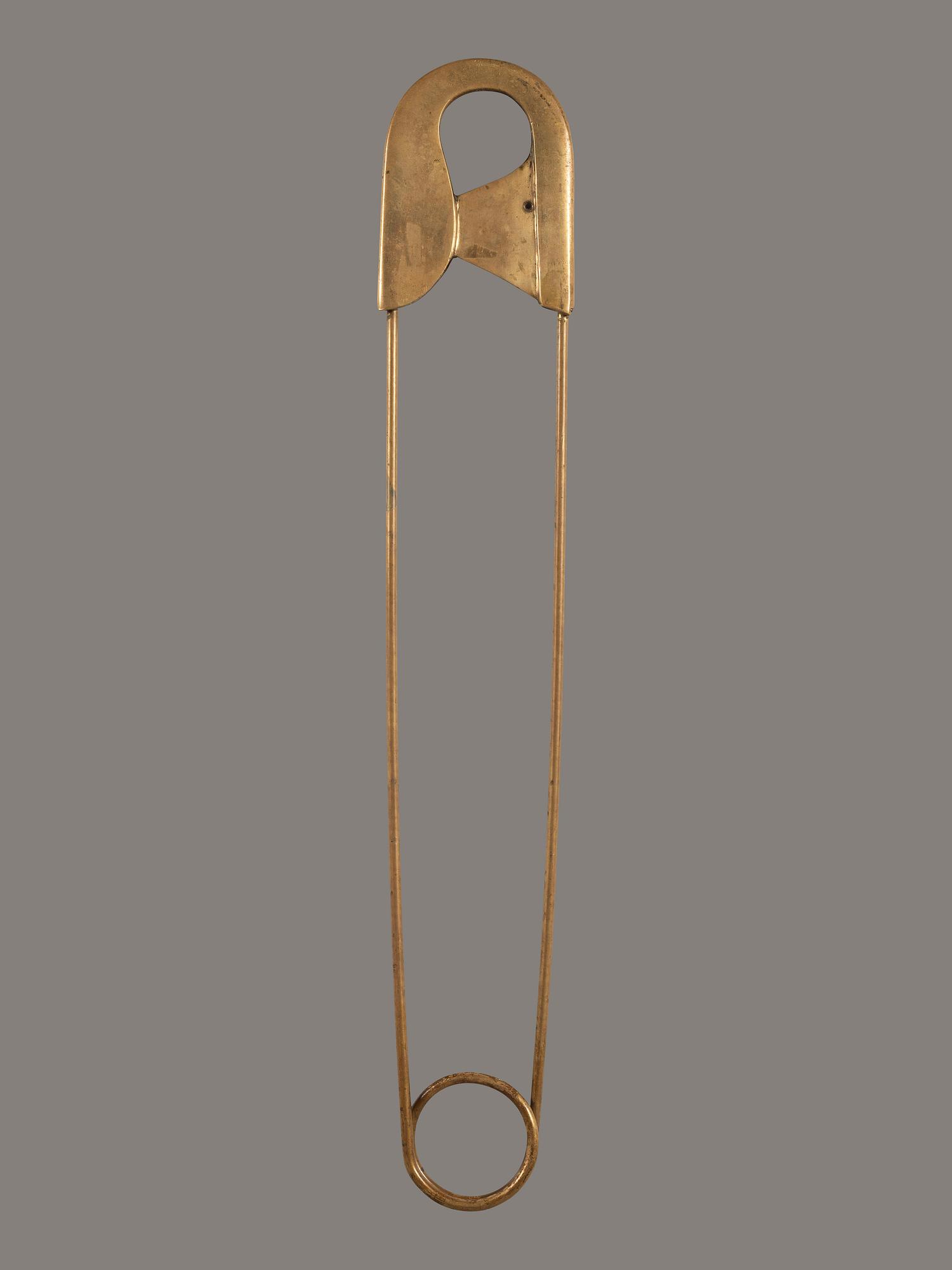 A Gold Painted Bronze Safety Pin Shop Sign