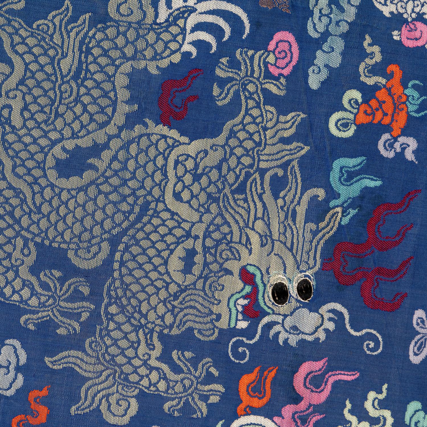 A Chinese Blue Ground Brocade 'Dragon' Robe, Jifu, Late Qing Dynasty 清晚期 藍地織錦云龍紋吉服