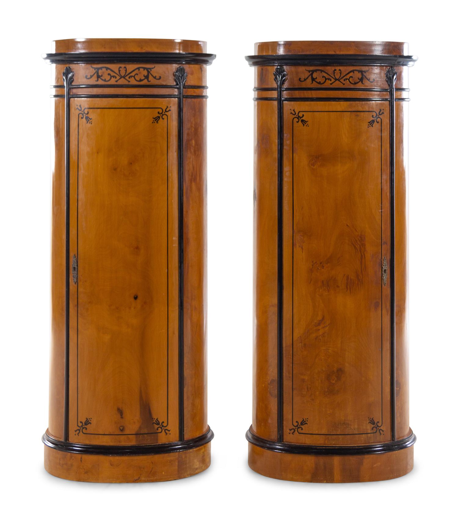 A Pair of Biedermeier Style Parcel Ebonized Satinwood Pedestal-Form Cabinets