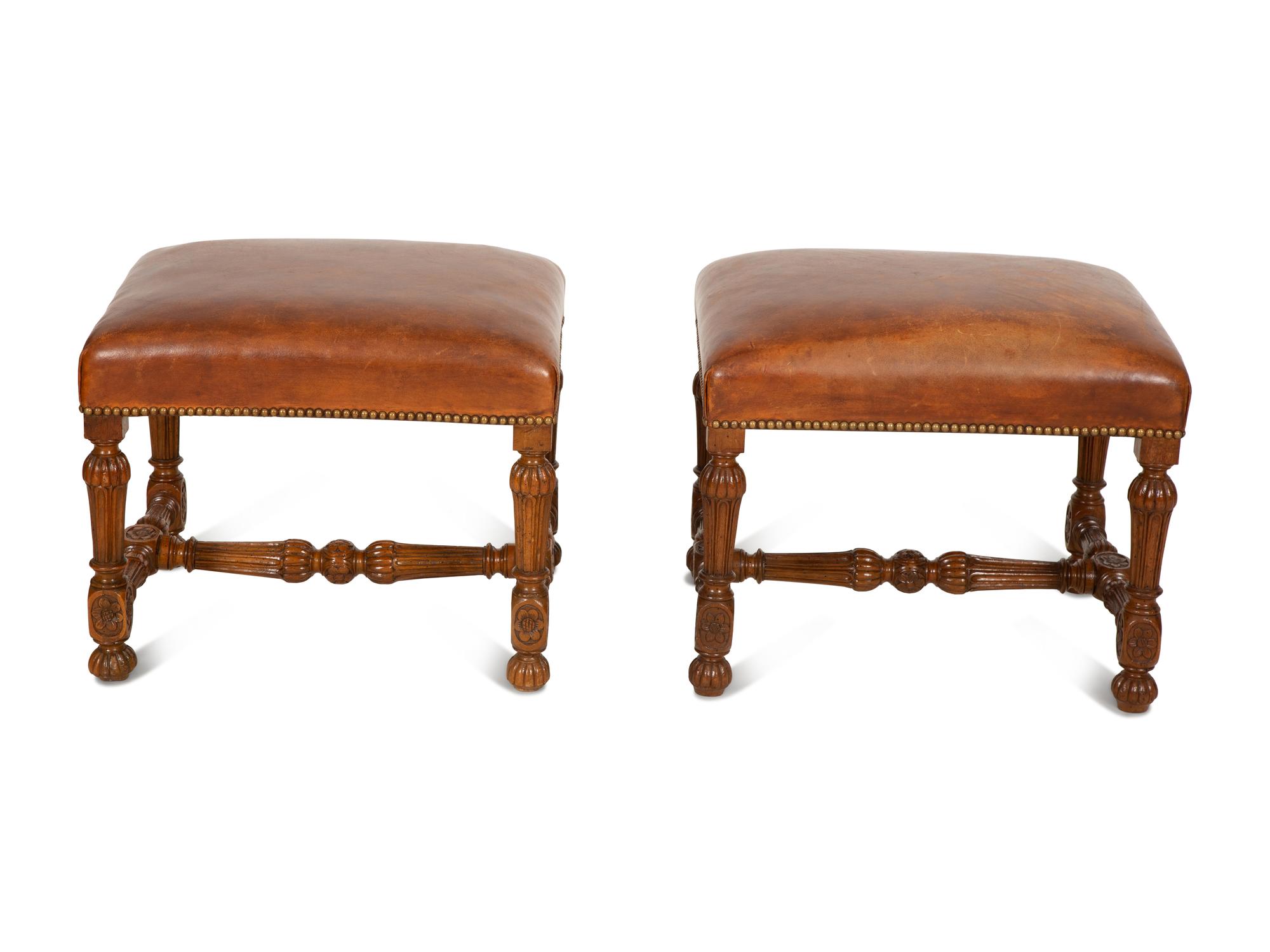 A Pair of Carved Walnut Regence Style Leather Upholstered Stools