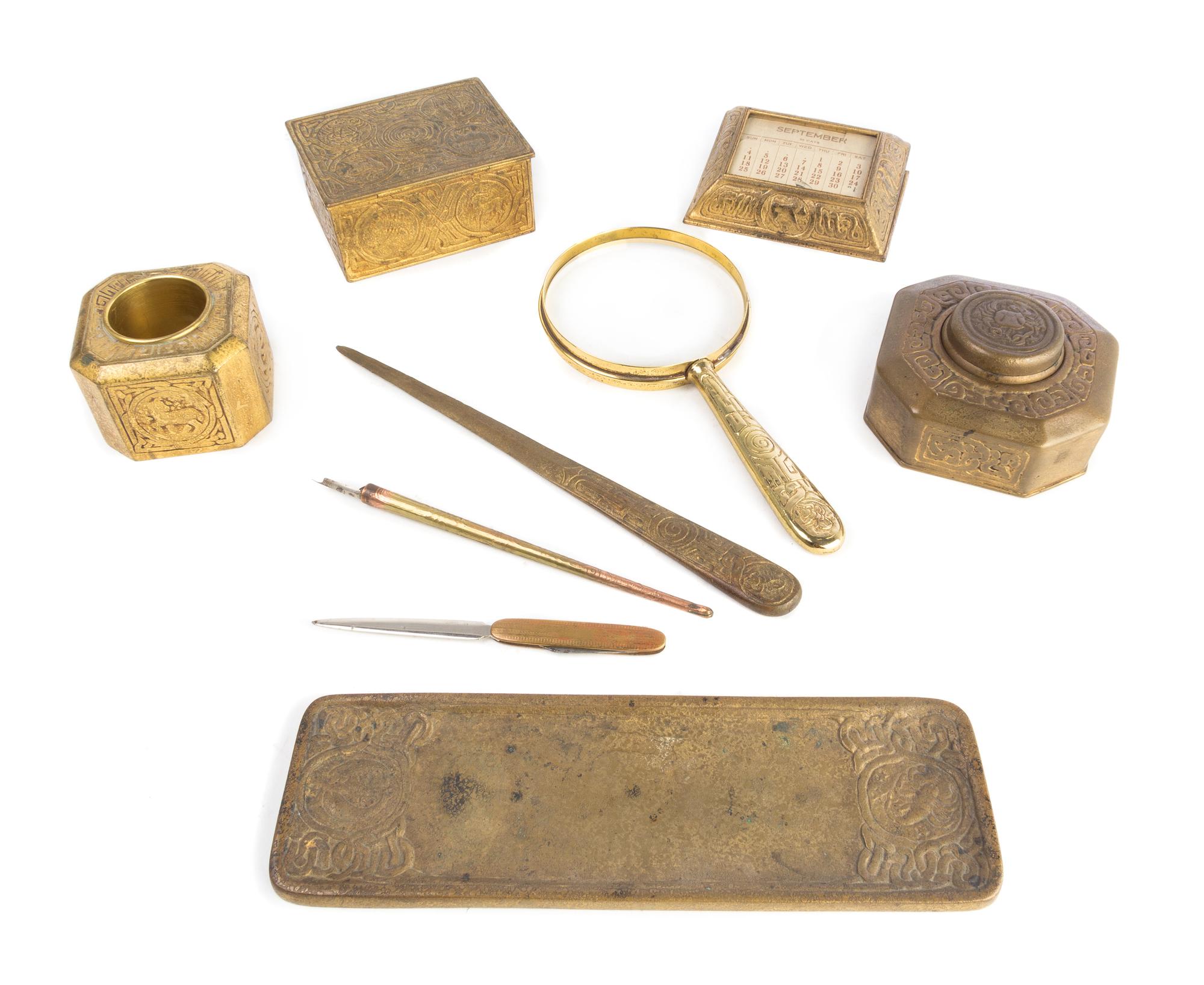 Tiffany Studios, a Zodiac pattern bronze dore nine-piece desk set