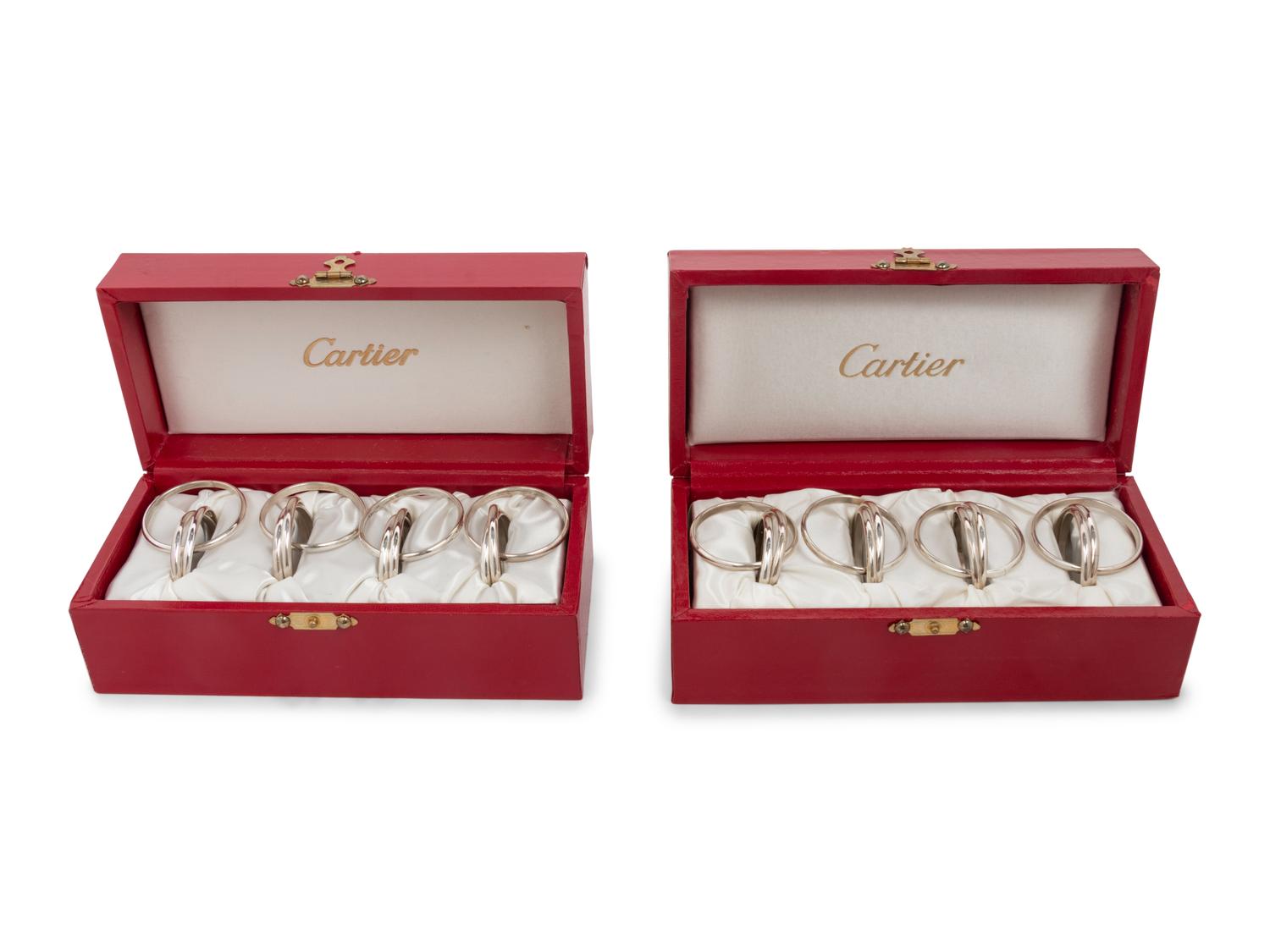 Two Cased Sets of Four Cartier Trinity Silver Napkin Rings