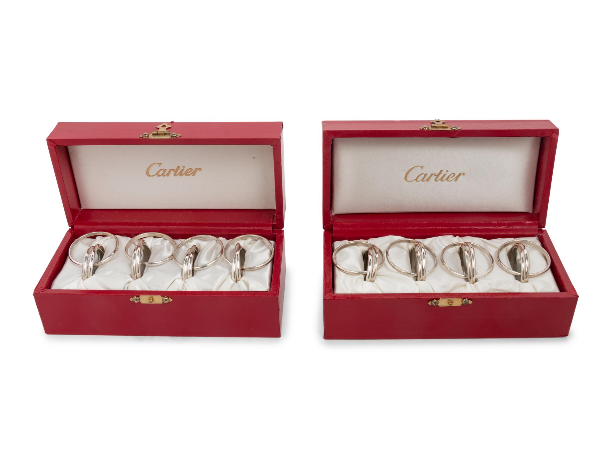 Two Cased Sets of Four Cartier Trinity Silver Napkin Rings