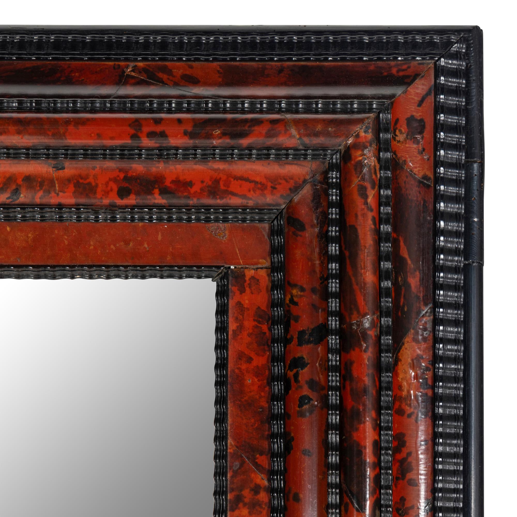 A Flemish Part-Ebonized and Tortoiseshell Veneered Ripple-Molded Mirror