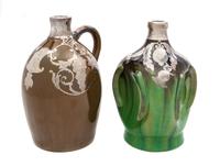 Two Musical Ceramic Silver Overlay Jugs Height of taller 8 7/8 inches.