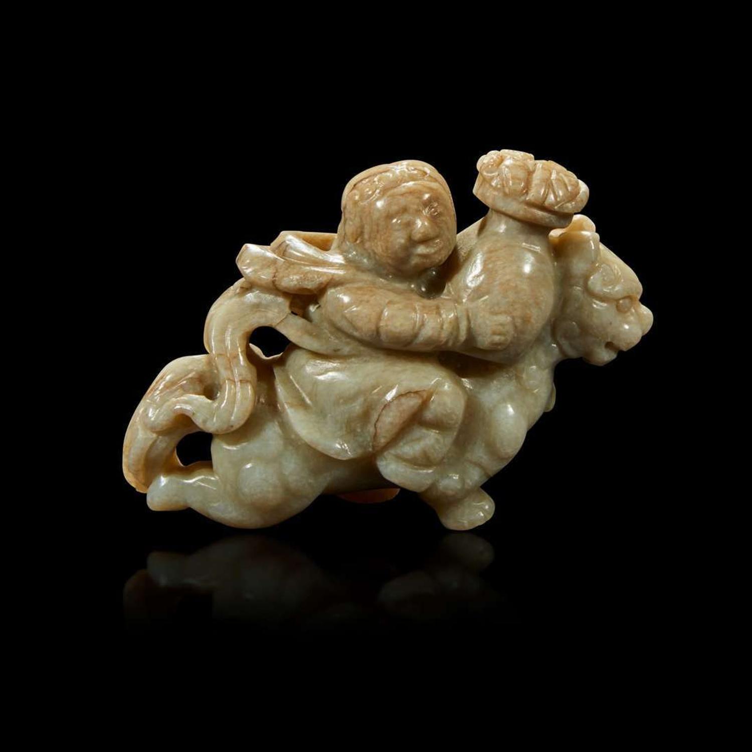 A Chinese greyish white jade carving of a foreigner on a mythical beast 18th Century or earlier
