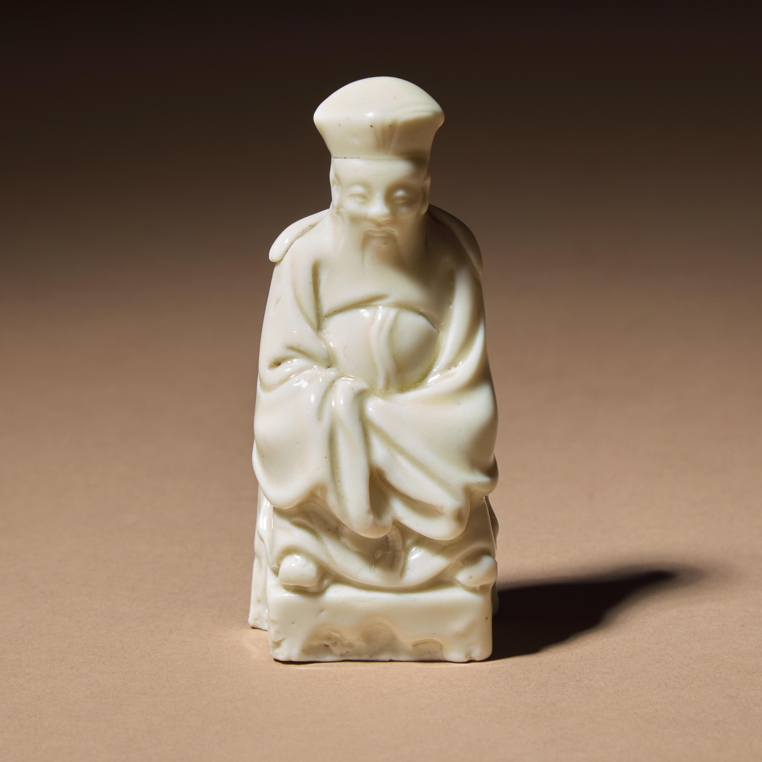 A Chinese Blanc-de-Chine Porcelain Seated Figure of a Dignitary, 17th Century — 清早期 德化白瓷文官坐像