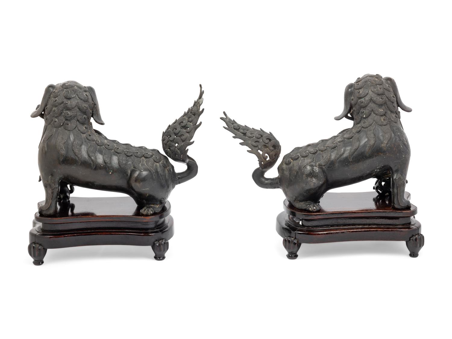 A Pair of Chinese Bronze Buddhistic Lions with Wood Stands