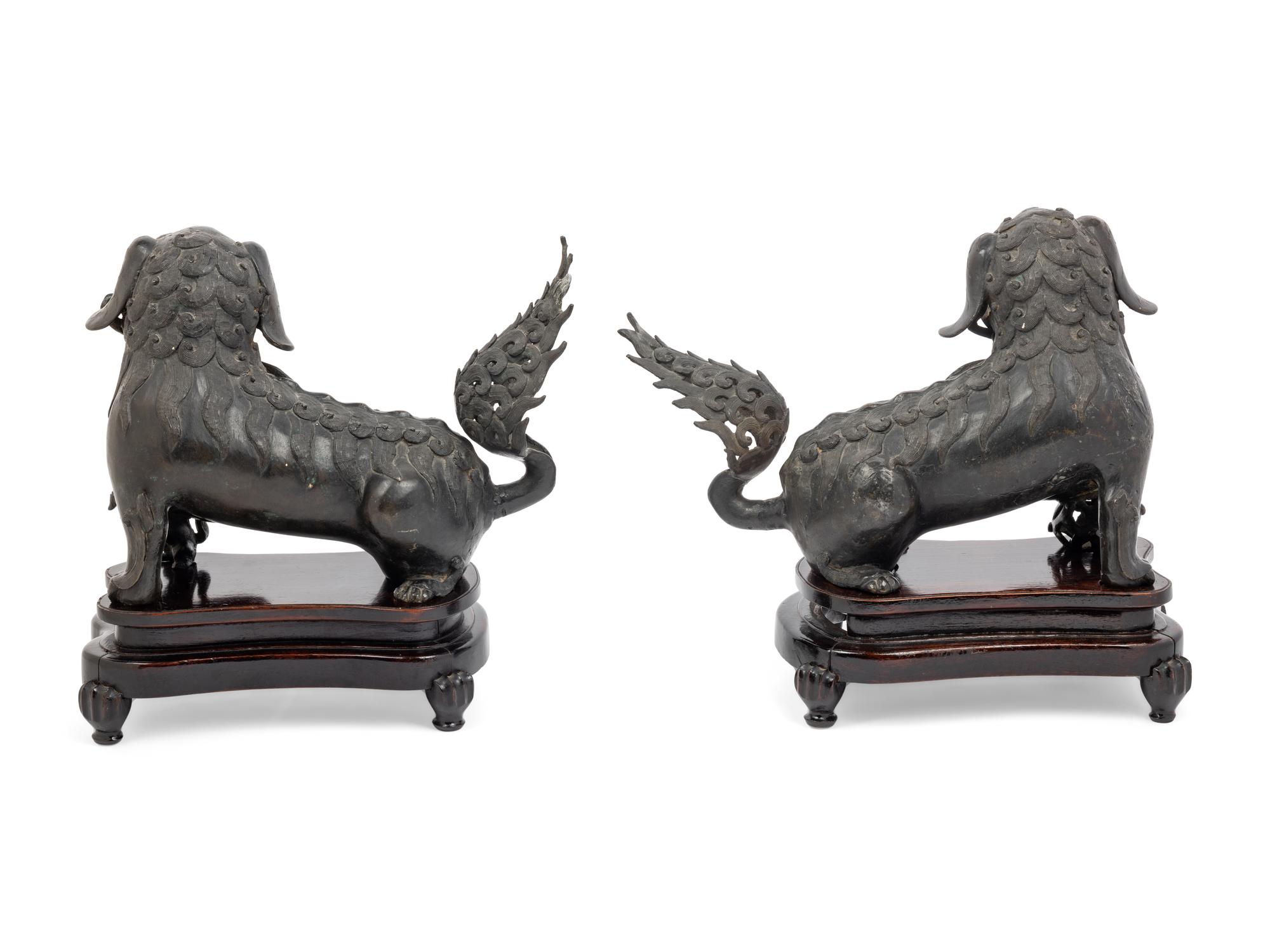 A Pair of Chinese Bronze Buddhistic Lions with Wood Stands
