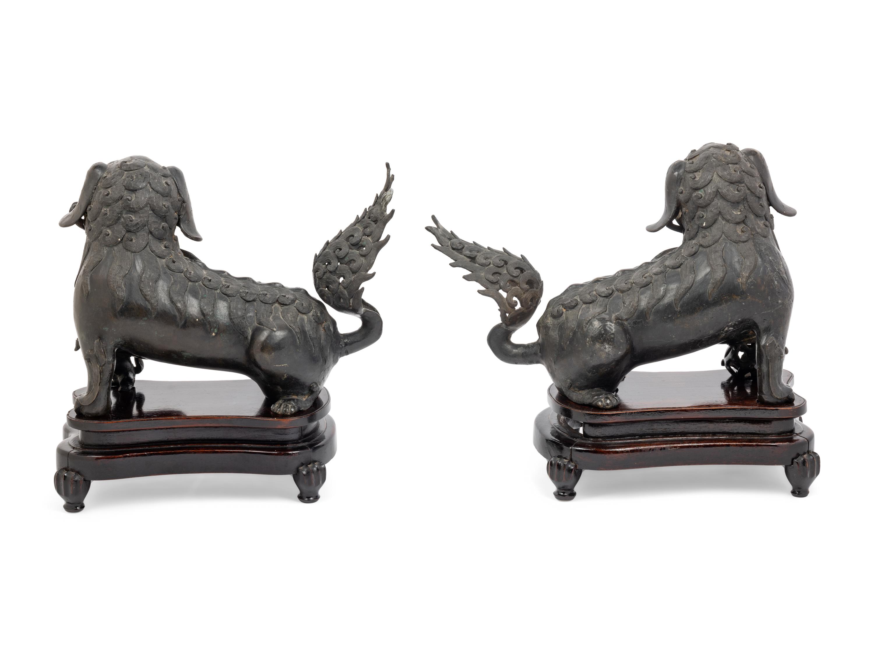 A Pair of Chinese Bronze Buddhistic Lions with Wood Stands