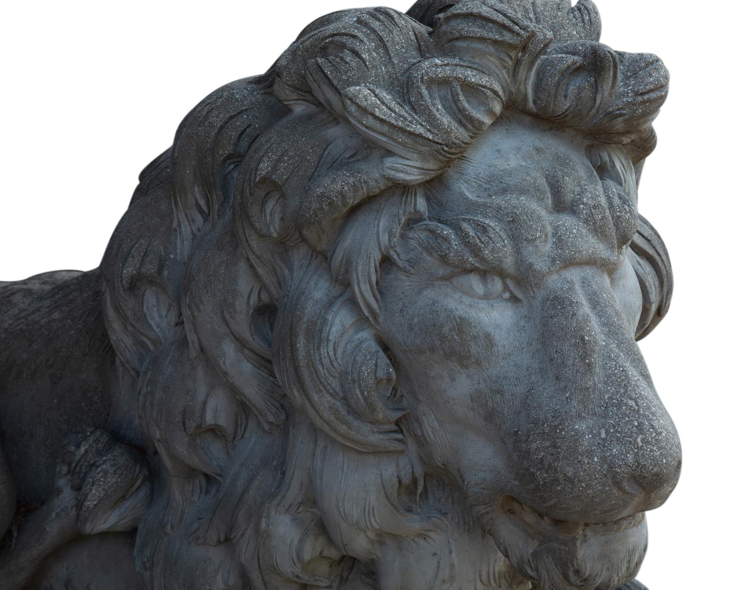 A Pair of Cast Stone Recumbent Lions on Pedestal Bases