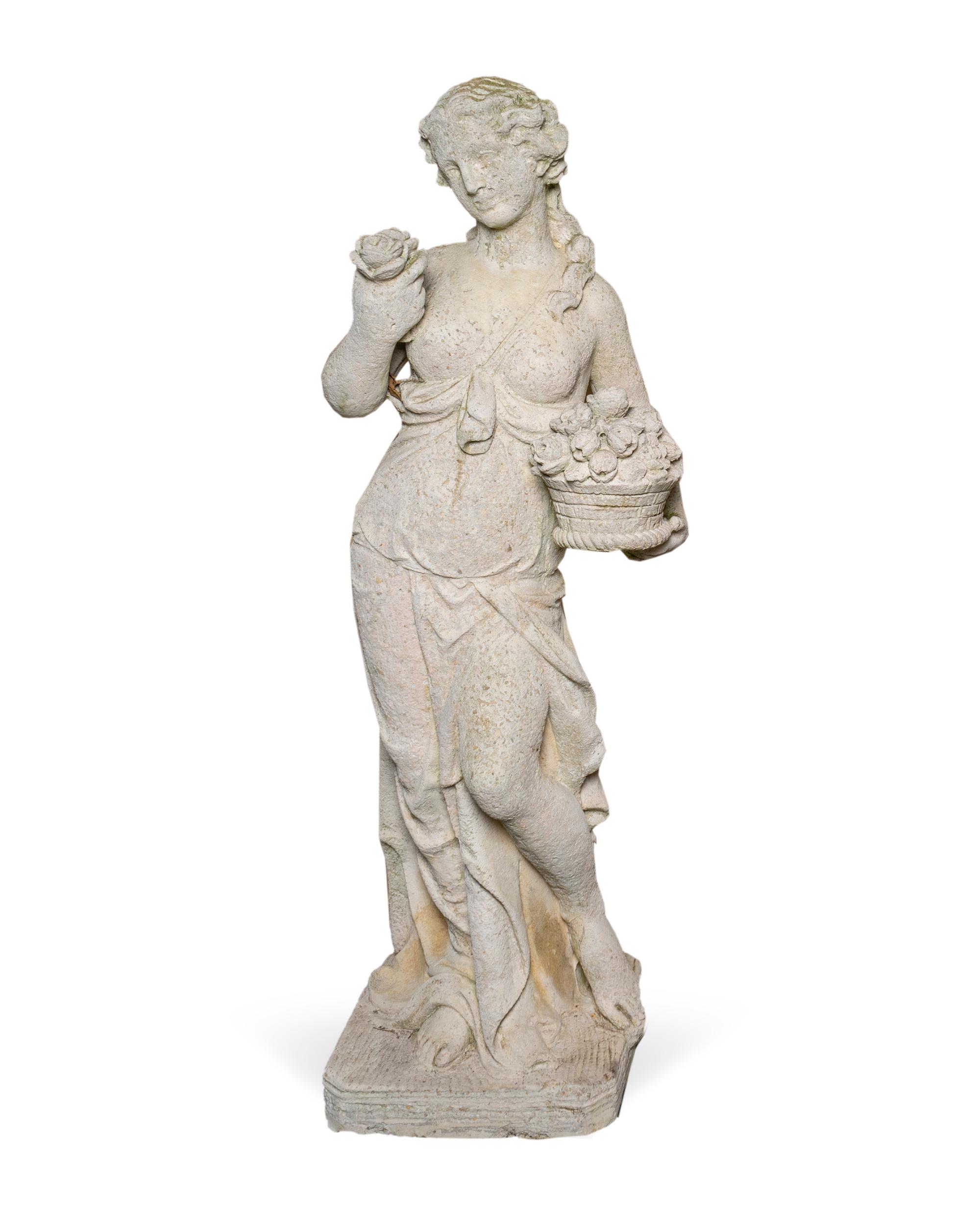 A Cast Stone Figure of a Young Woman Holding a Basket of Flowers — EARLY 20TH CENTURY