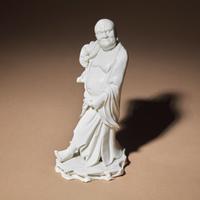 A Chinese Blanc-de-Chine Porcelain Standing Figure of a Luohan, Qing Dynasty — 清 德化白瓷羅漢立像