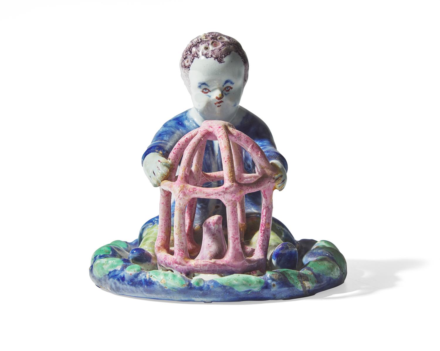 A small Dutch Delft figure of a boy holding birdcage with bird, 18th century