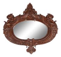 A Carved Mahogany Oval Mirror with Opposing Griffins