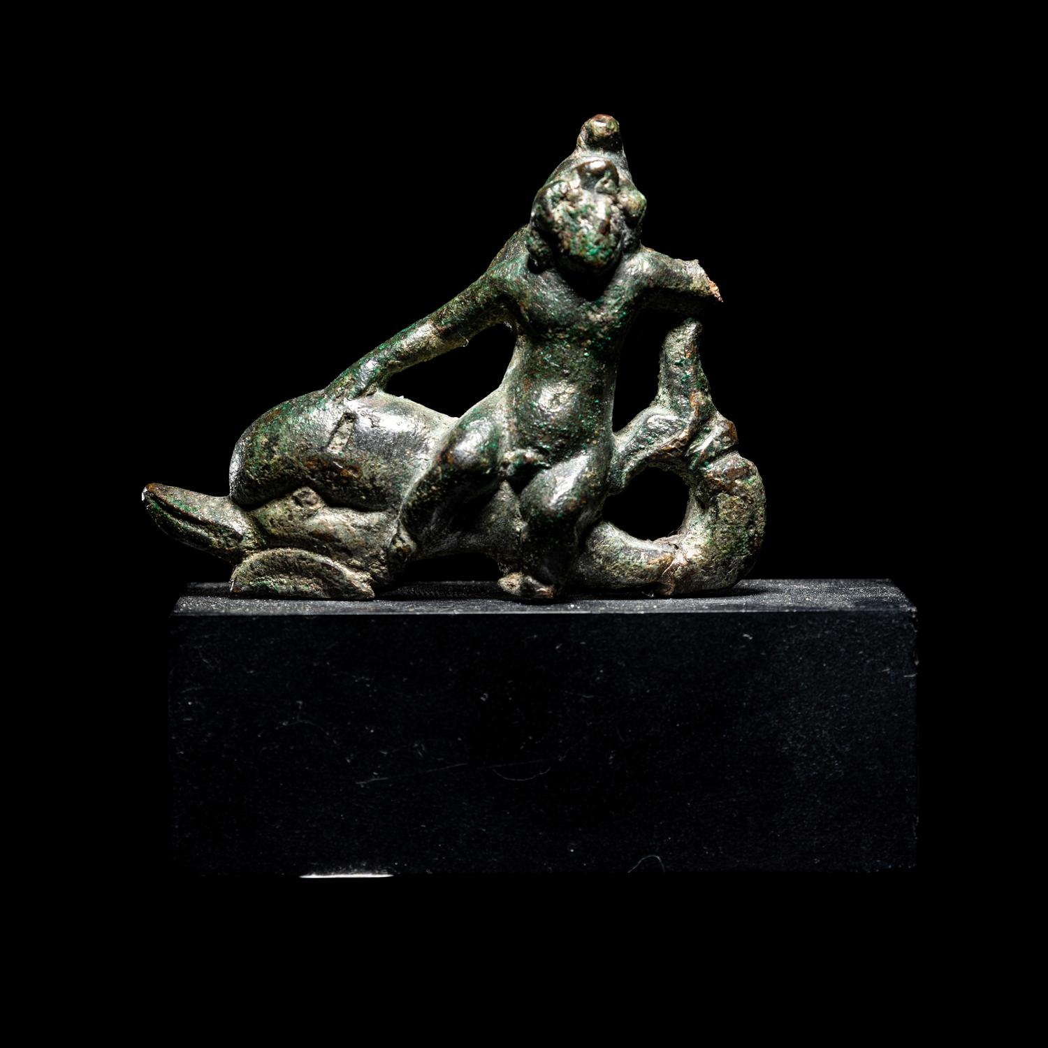 A Roman Bronze Eros Riding a Dolphin