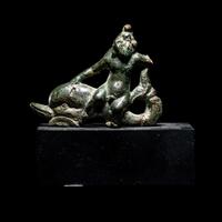 A Roman Bronze Eros Riding a Dolphin