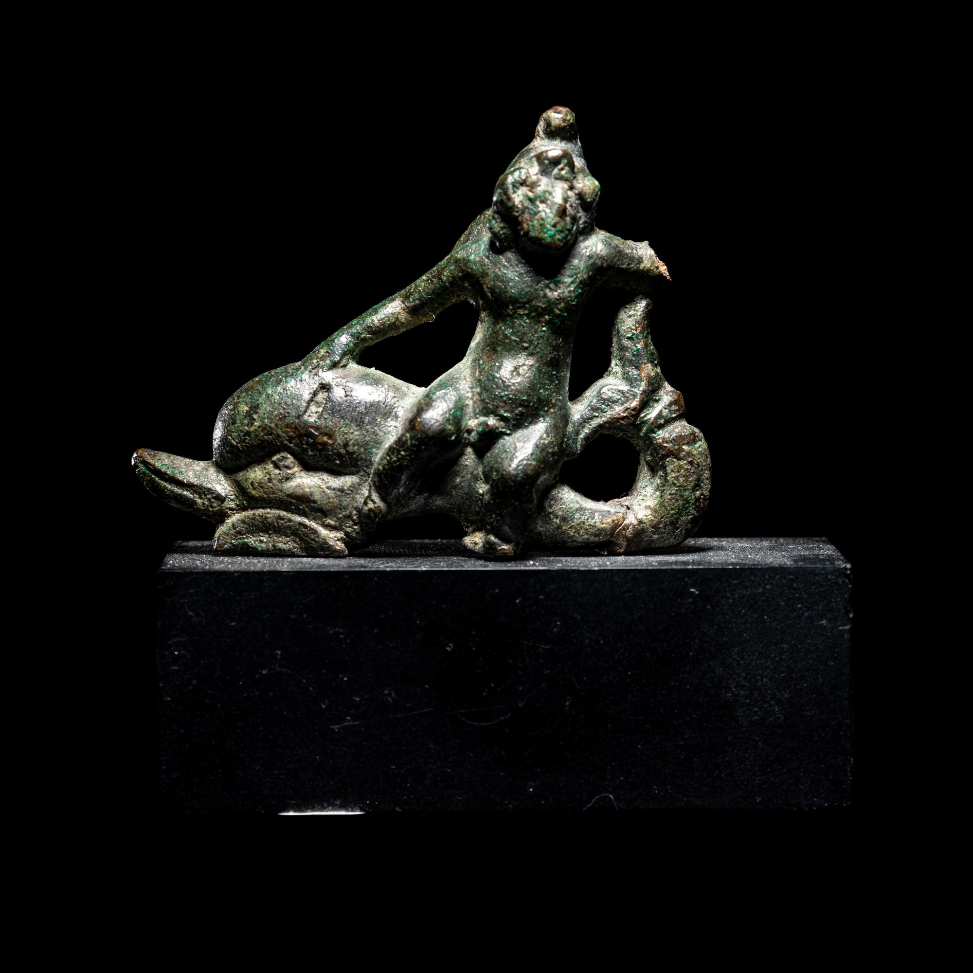 A Roman Bronze Eros Riding a Dolphin