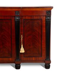 A Late Regency Style Figured Mahogany Sideboard with Carved Ebonized Pilasters