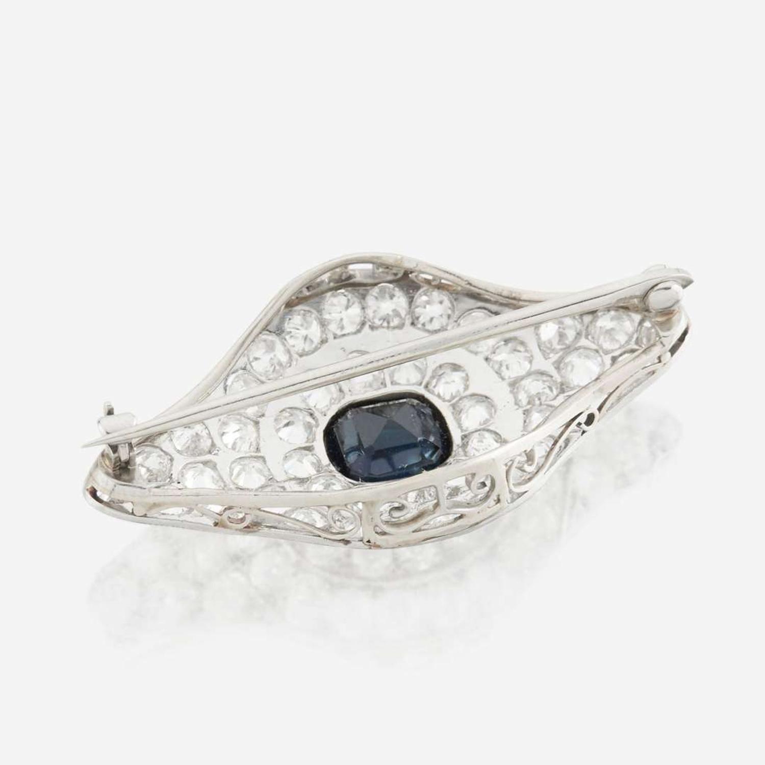 A sapphire, diamond, platinum, and white metal brooch