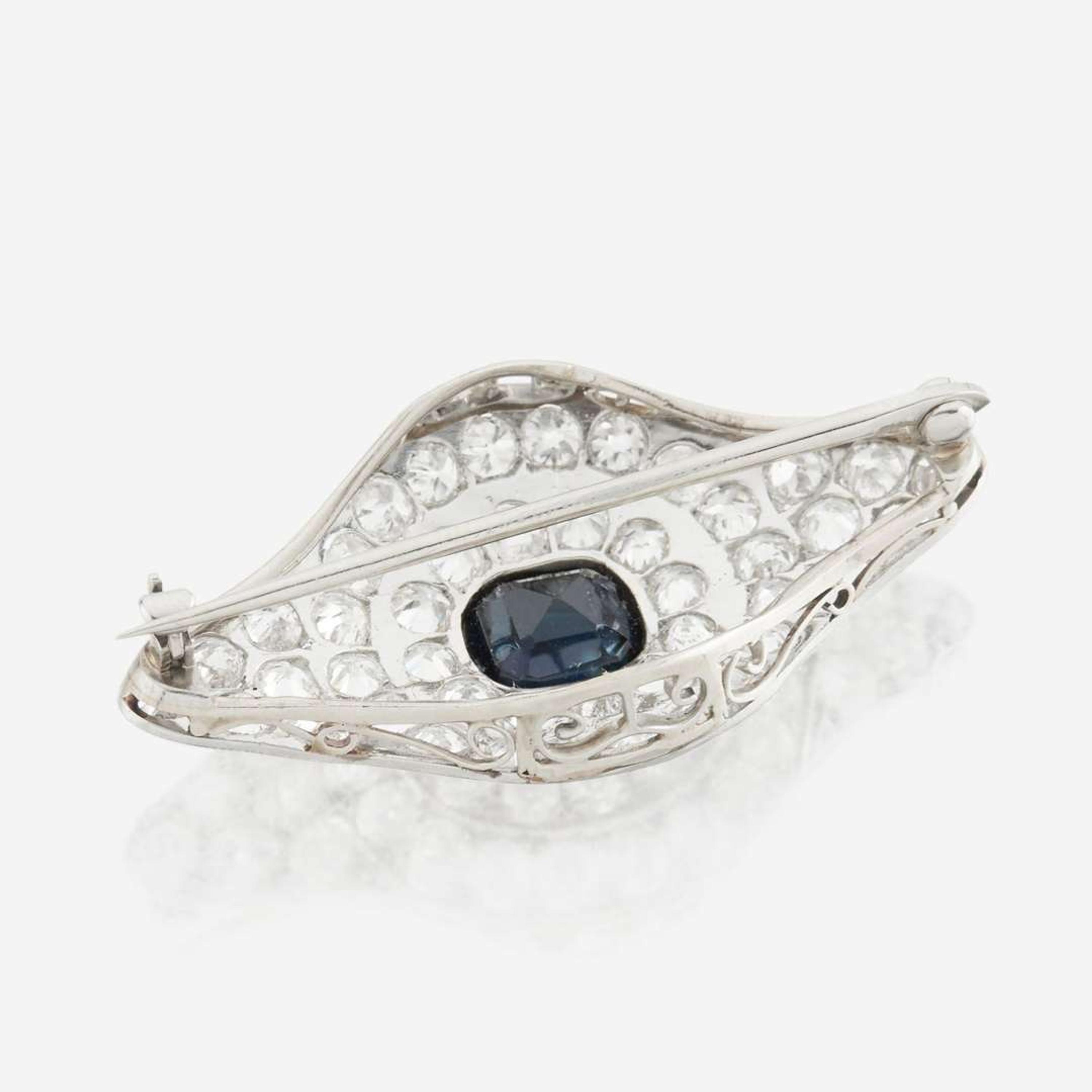 A sapphire, diamond, platinum, and white metal brooch