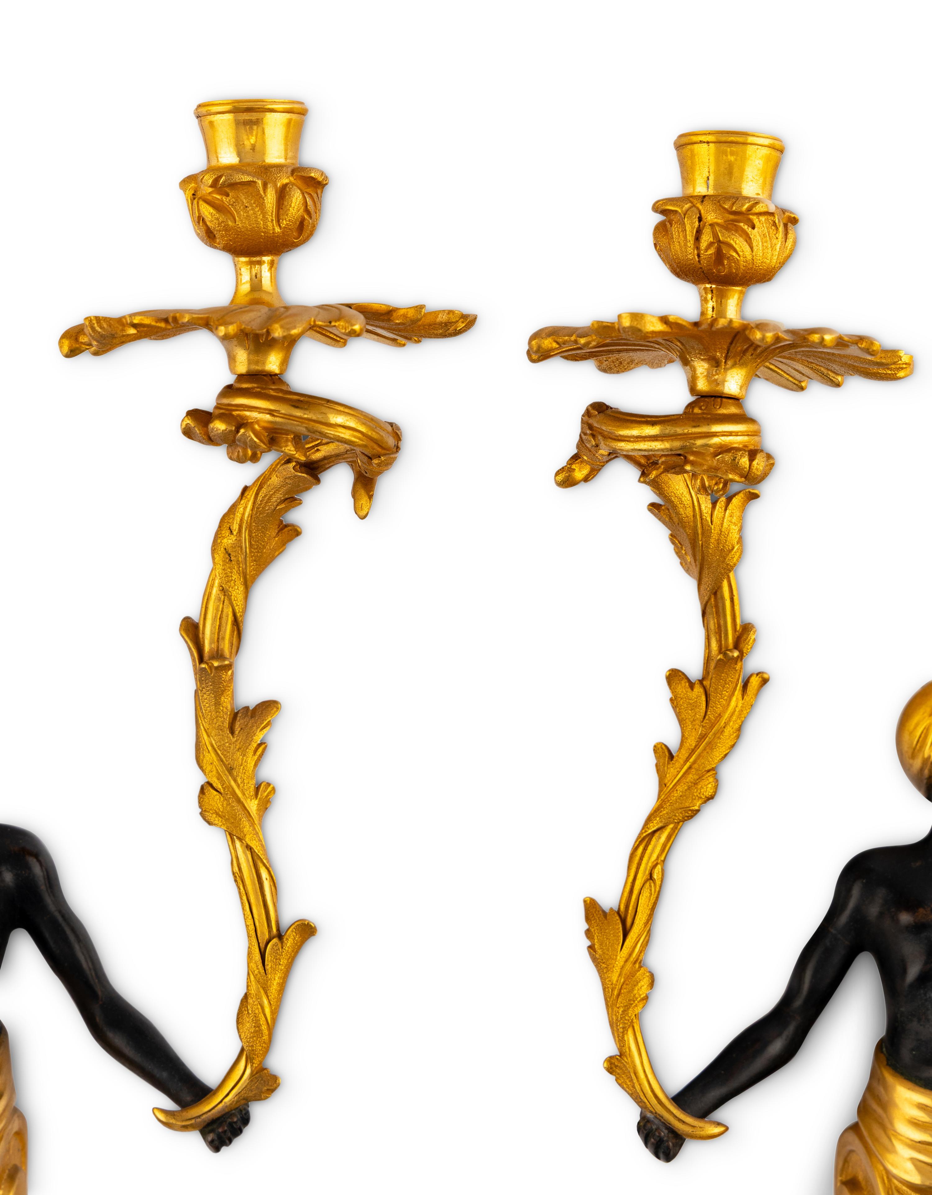 A Pair of French Gilt and Patinated Bronze Figural Two-Light Sconces
