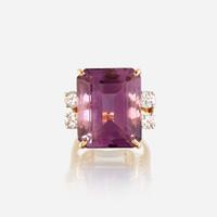 An amethyst, diamond, white stone, and gold ring