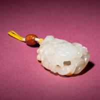 A Chinese Russet and White Jade Reticulated 'Lotus' Pendant, 18th/19th Century — 清中期 白玉帶皮鏤雕蓮紋佩
