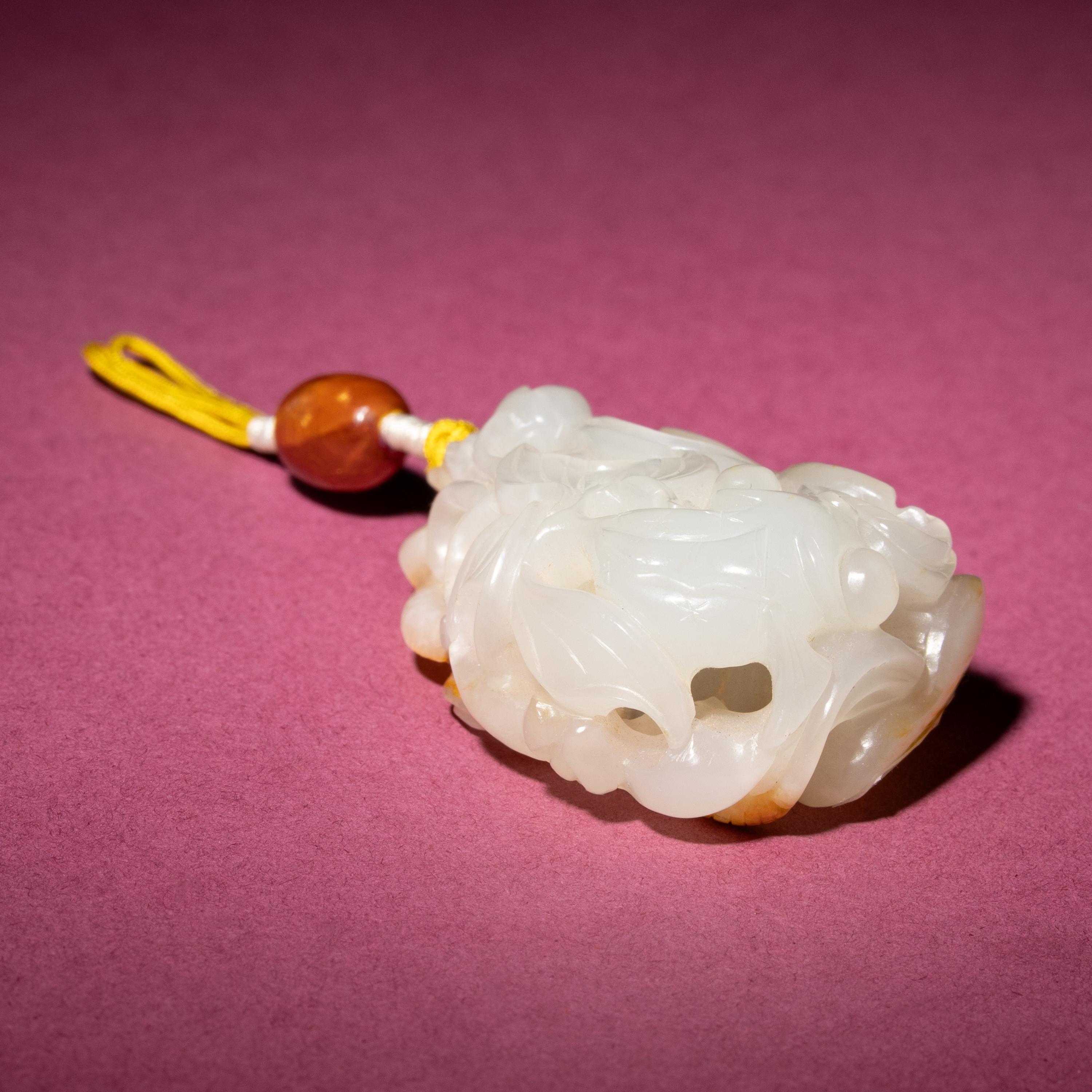 A Chinese Russet and White Jade Reticulated 'Lotus' Pendant, 18th/19th Century — 清中期 白玉帶皮鏤雕蓮紋佩