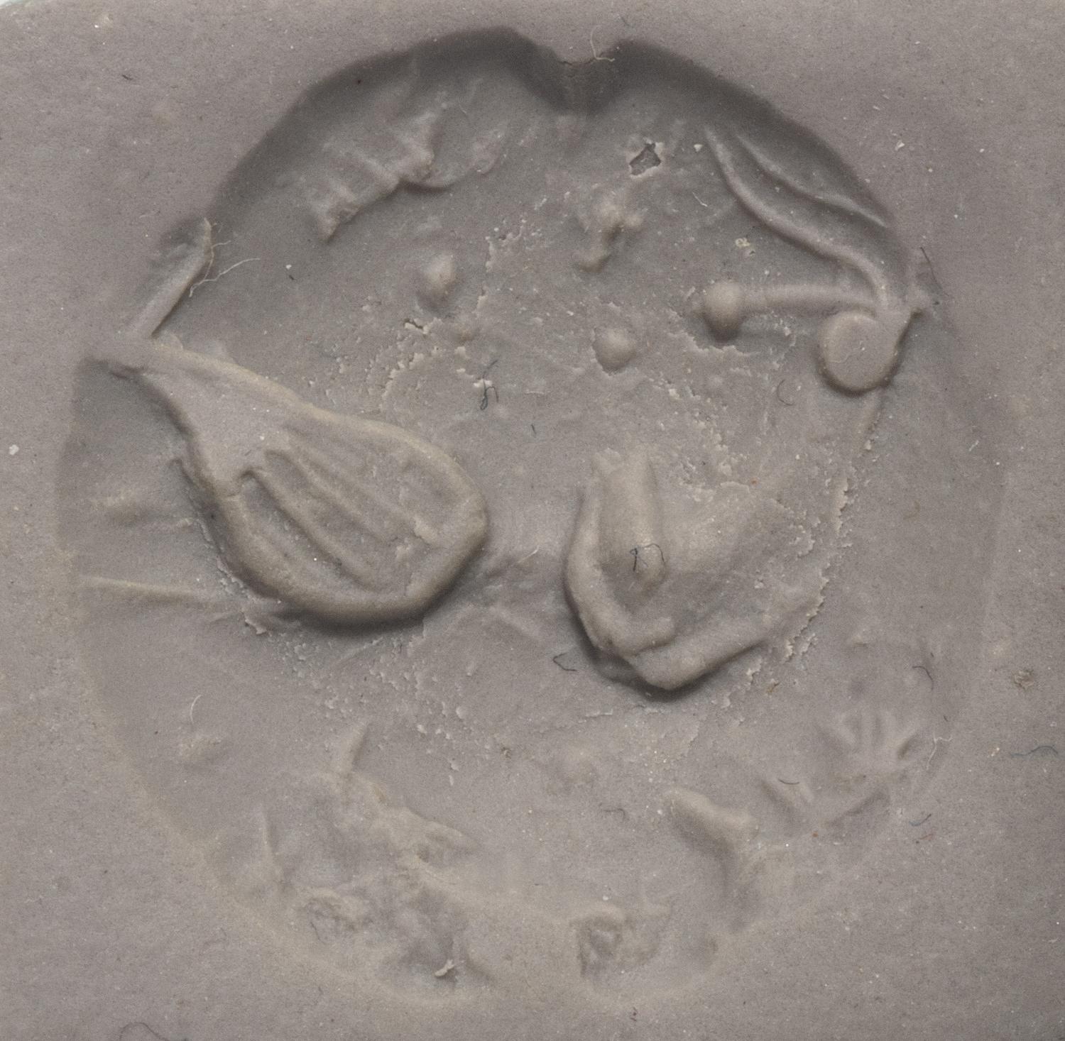A Minoan Black Steatite Lentoid with a Bull Head and Leaf.