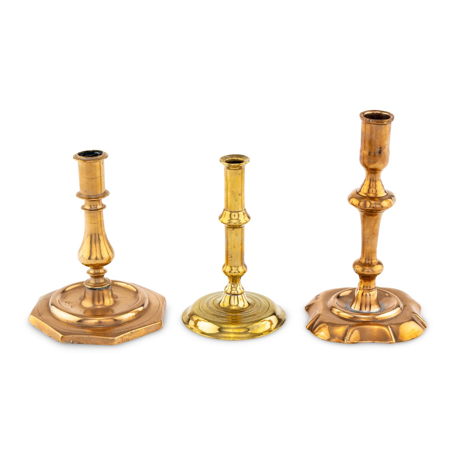 A Collection of Three Brass and Bell Metal Candlesticks