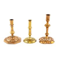 A Collection of Three Brass and Bell Metal Candlesticks