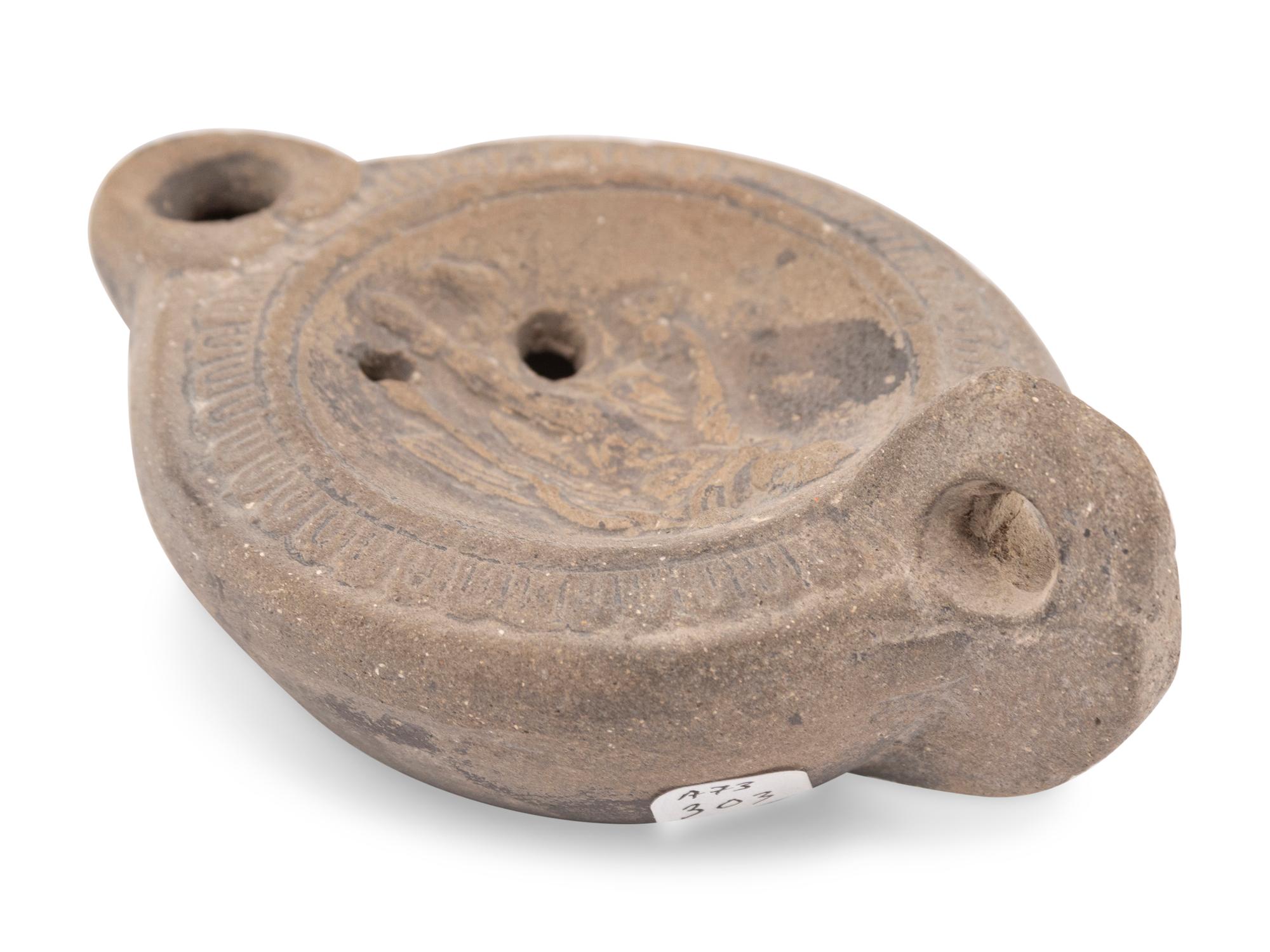 A Roman Discus Lamp Depicting Dionysos Holding a Thyrsos and a Bunch of Grapes