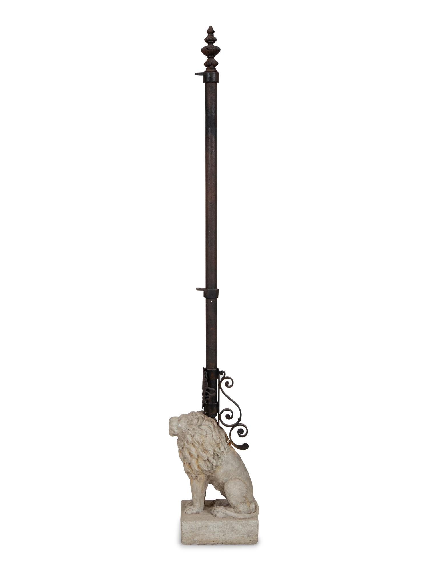A Cast Stone Seated Lion with Iron Flag Pole in the Manner of Mizner