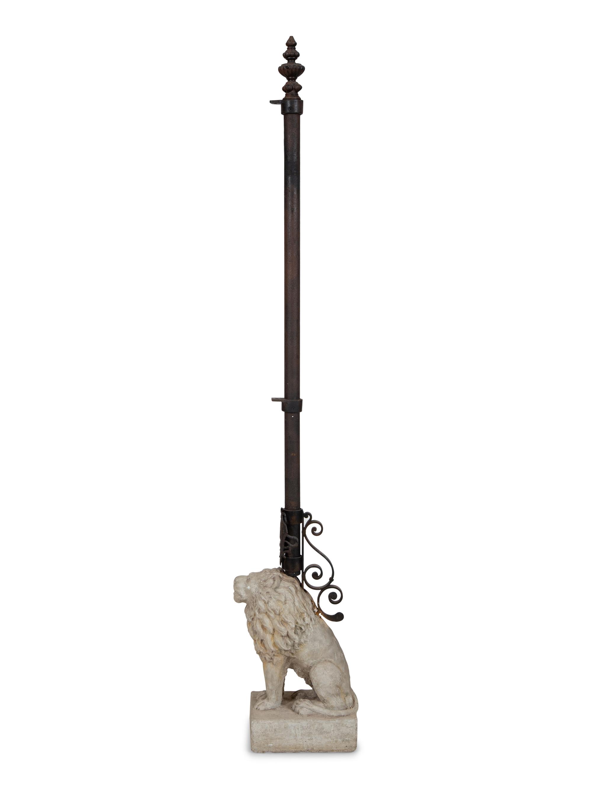 A Cast Stone Seated Lion with Iron Flag Pole in the Manner of Mizner