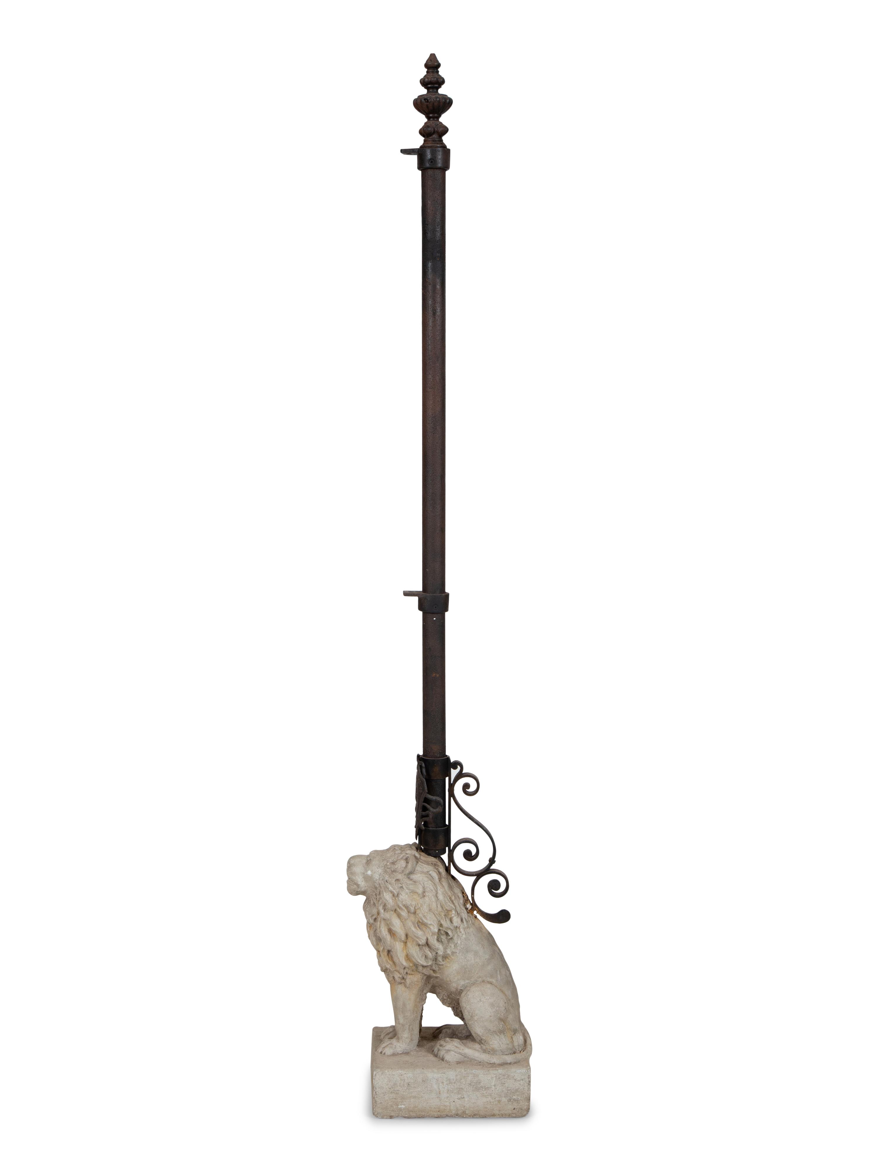 A Cast Stone Seated Lion with Iron Flag Pole in the Manner of Mizner