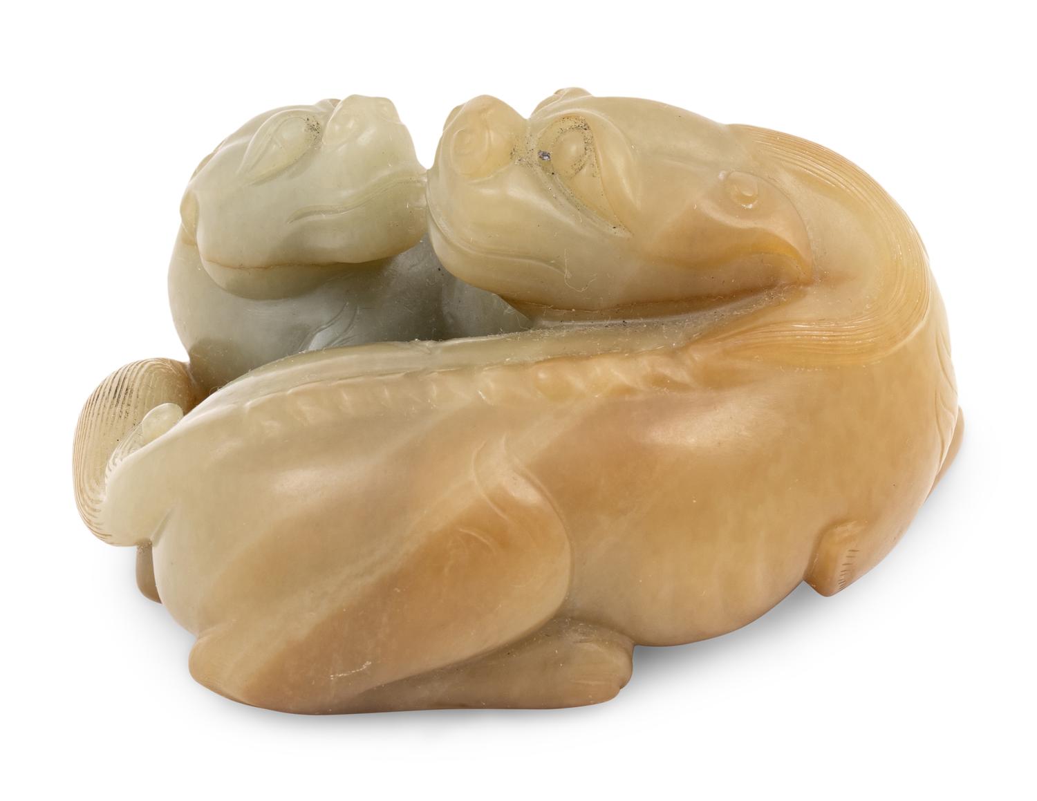 A Chinese Celadon and Russet Jade Carving of Two Mythical Beasts