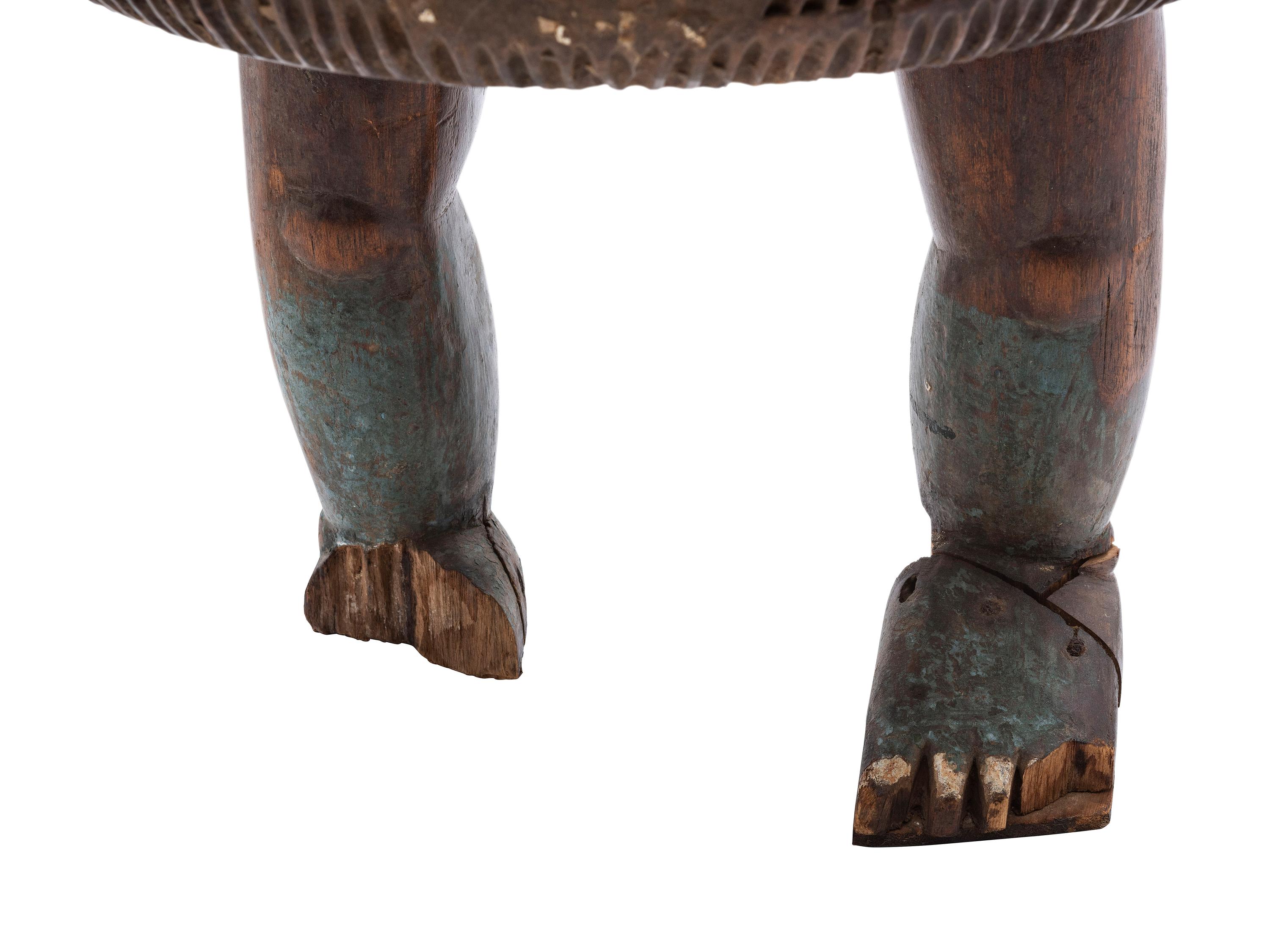 An Ashanti Carved and Gouged Painted Wood Breasted Drum