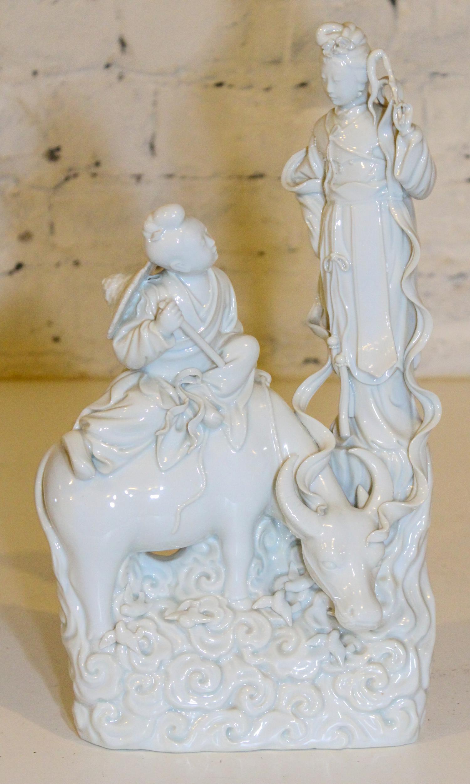 A Blanc de Chine Figural Group. Height 14 inches.