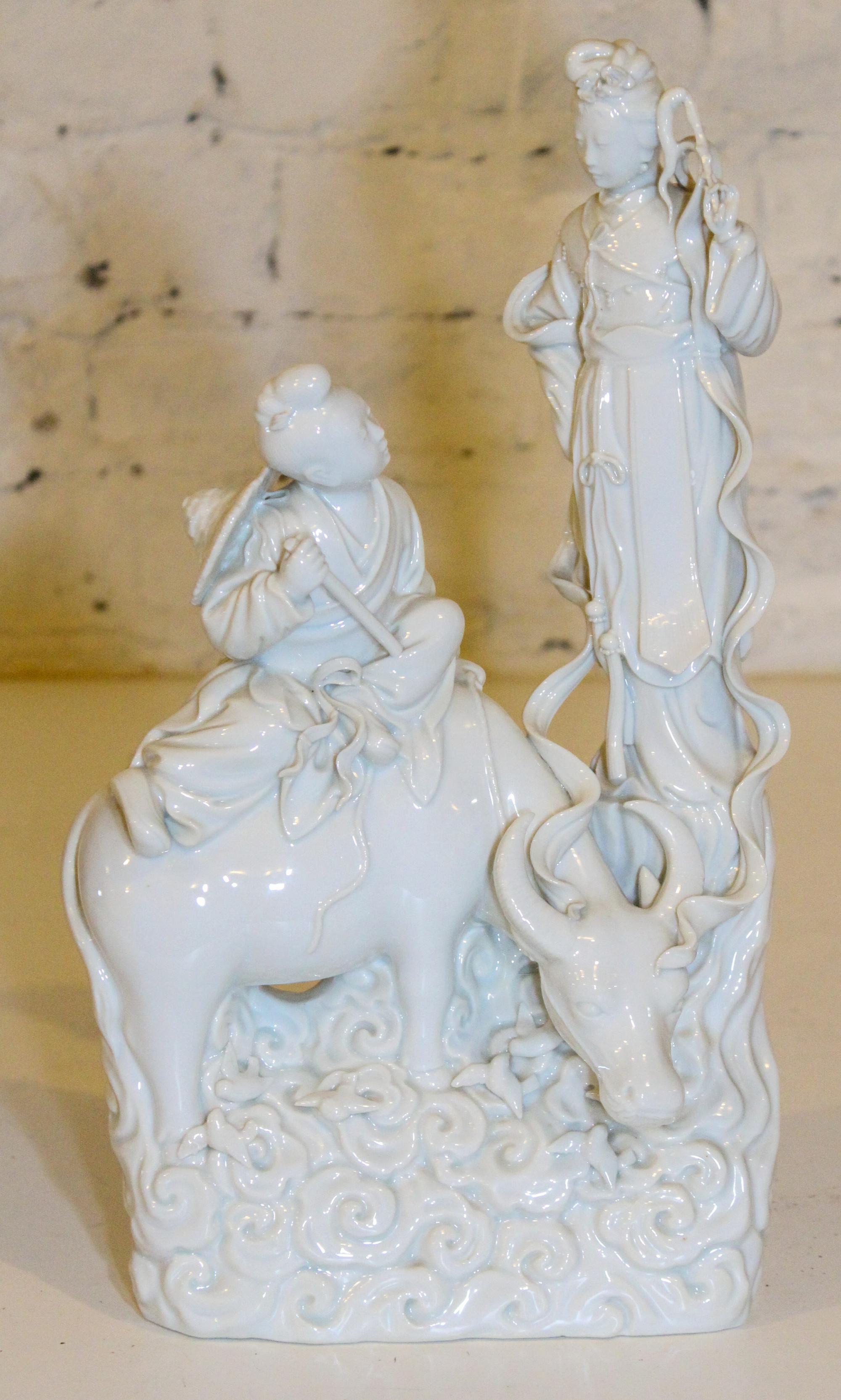 A Blanc de Chine Figural Group. Height 14 inches.
