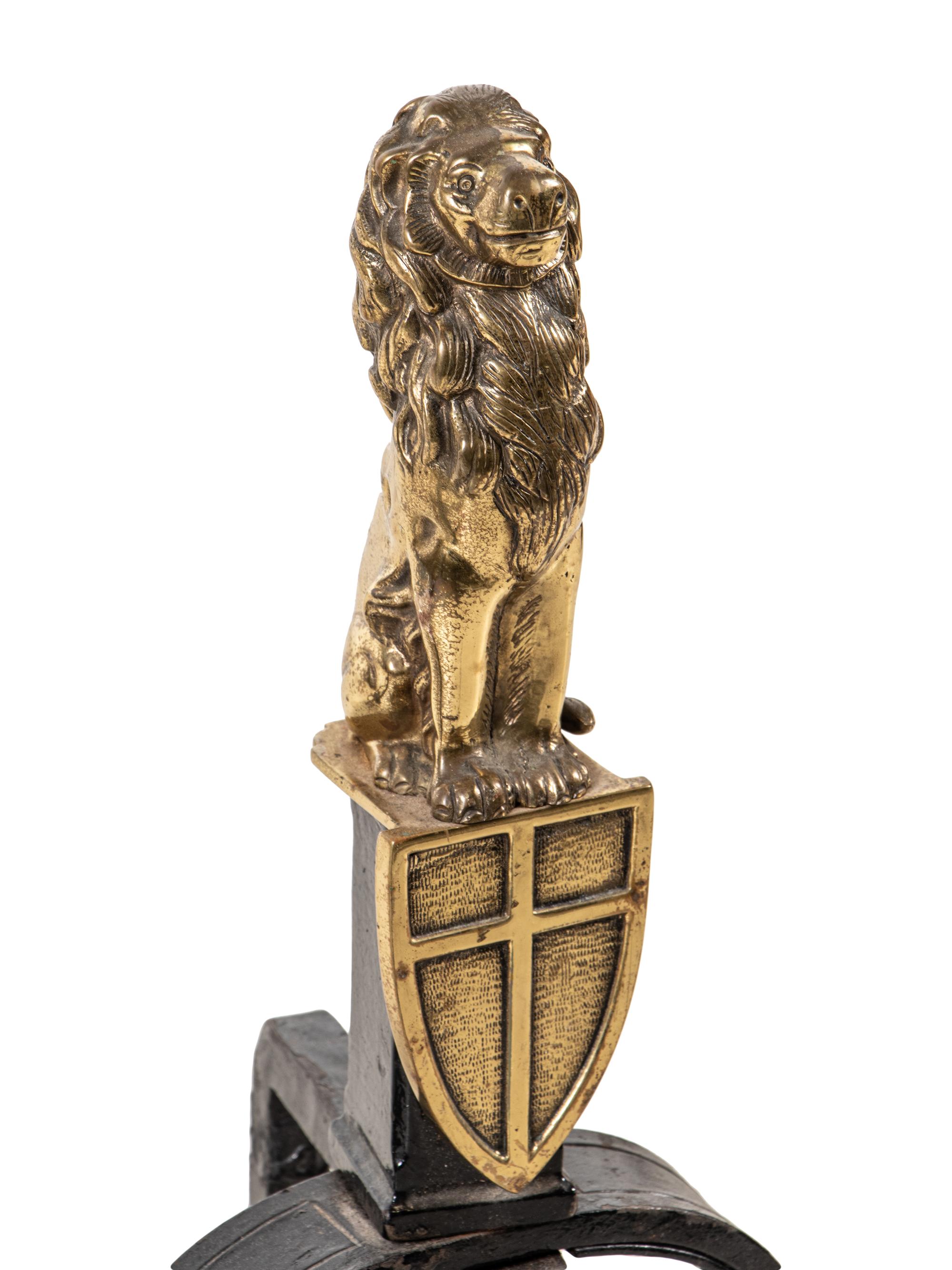 A Pair of English Gilt Brass and Black Painted Iron Andirons with Lion Finials