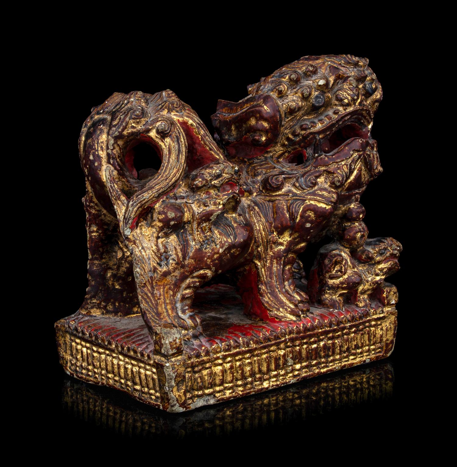 A Chinese Gilt and Red Painted Stone Fu Lion