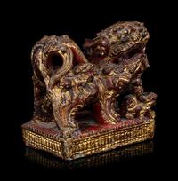 A Chinese Gilt and Red Painted Stone Fu Lion