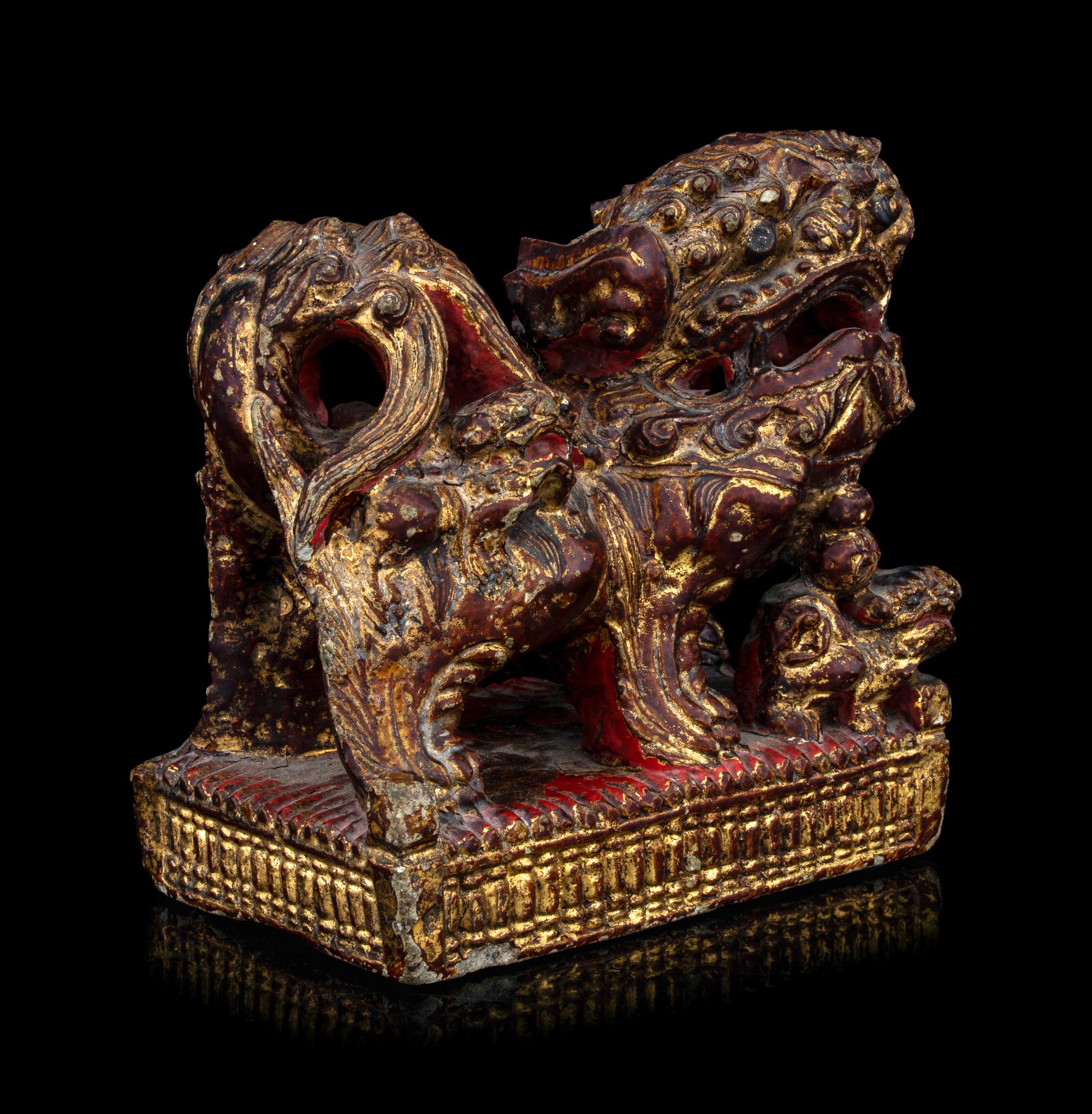 A Chinese Gilt and Red Painted Stone Fu Lion