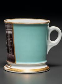 A Paint Enhanced Photographic Transfer Porcelain Occupational Shaving Mug Depicting a Tailor's Shop