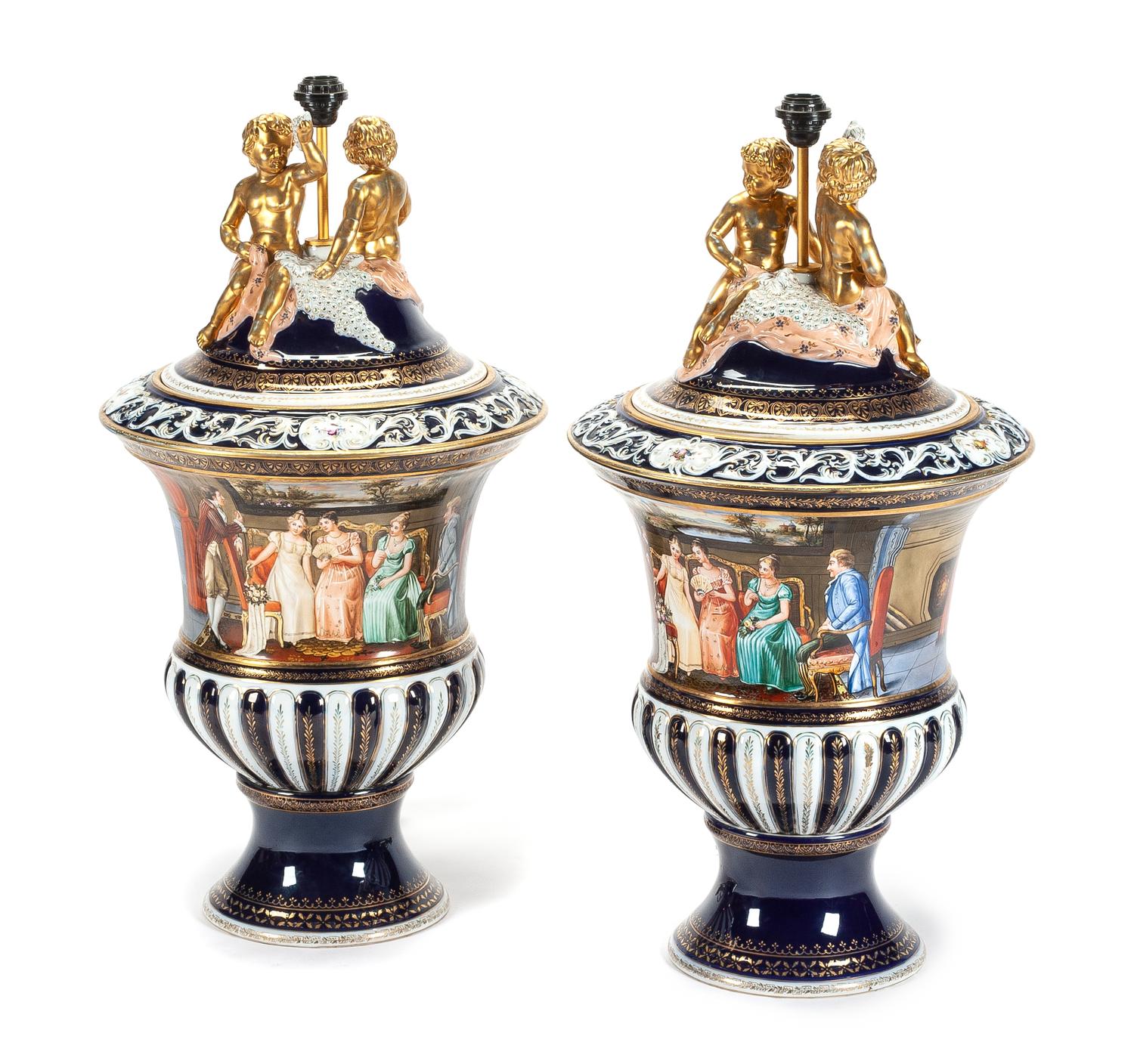 A Pair of Continental Porcelain Covered Urns Height overall 35 inches.