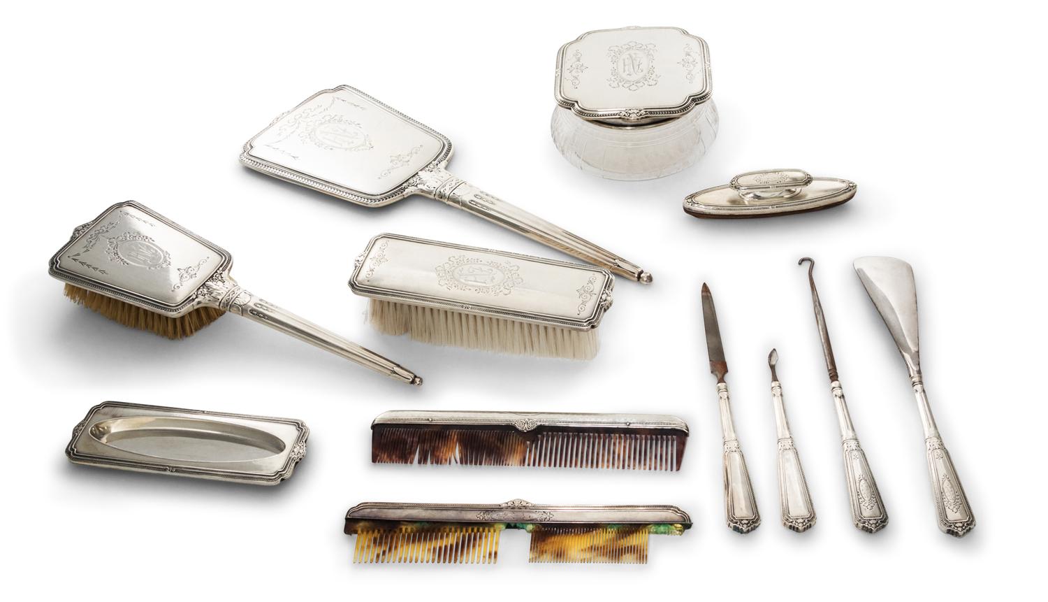 An American Silver Mounted Dresser Set, 20th century, comprising a hand mirror, a glass powder jar with a silver lid, two brushes, two