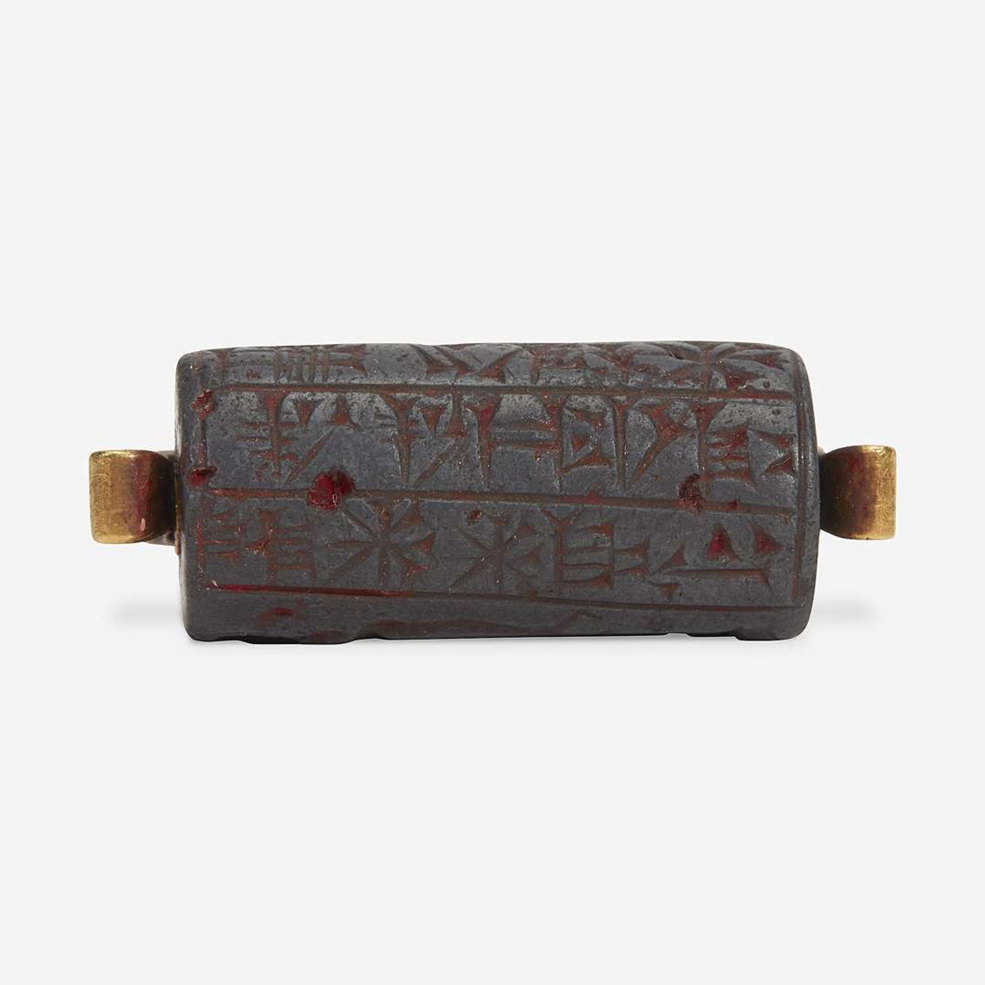 A Babylonian carved hematite cylindrical seal second millenium B.C.