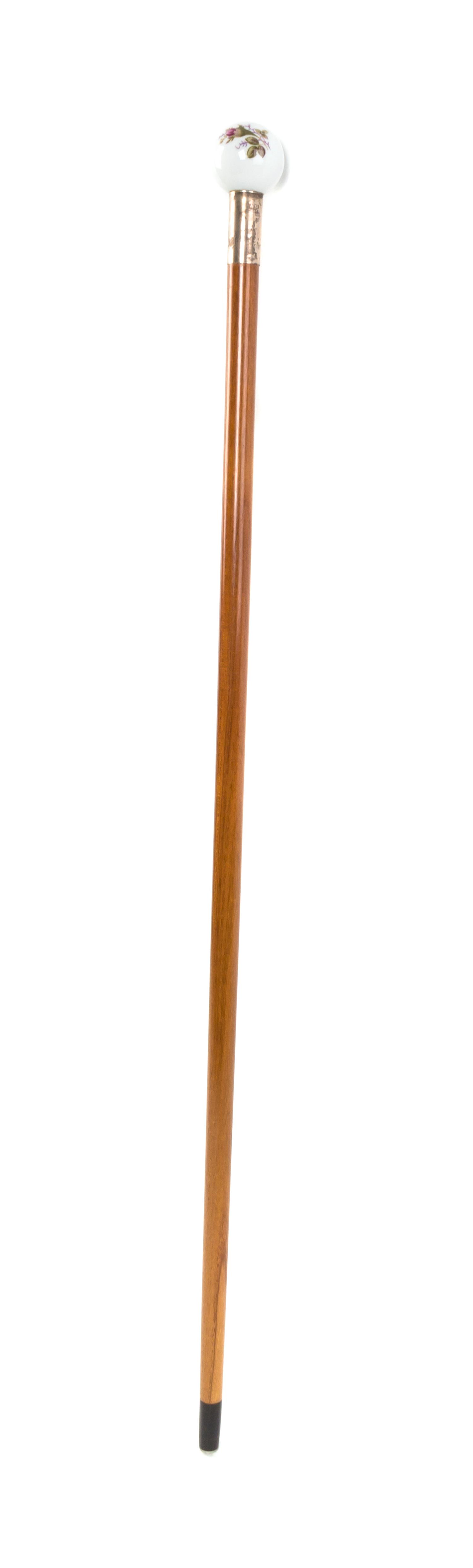 An American Porcelain Handled Walking Stick, Diameter of handle 1 3/4 x length overall 34 3/4 inches.