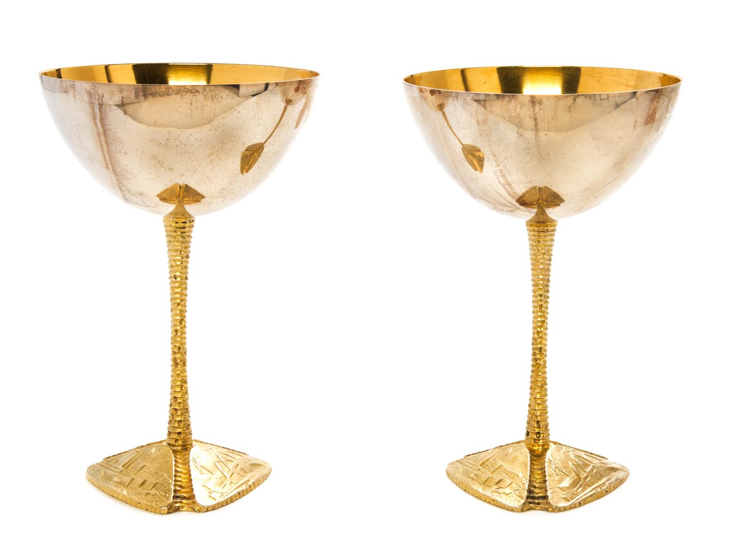 A Pair of Silver and Silver-Gilt Commemorative Goblets, Stuart Devlin, 1973, each raised on a tripartite foot embossed with scenes of t